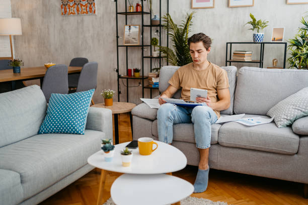 istock Young Man Checking His Finances On A Tablet At Home 1477111001