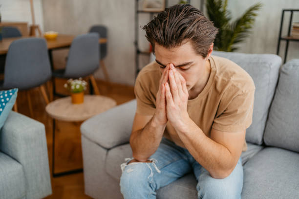 istock Sad Young Man Sitting At Home On The Sofa 1477114111