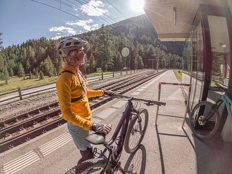 Woman with mountain bike waiting for public transportation