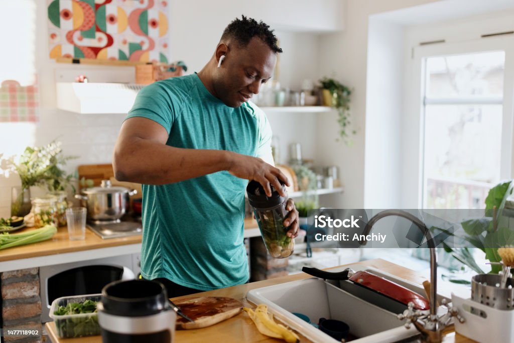 Post-Workout Refreshment Man making healthy smoothie in gym clothing Healthy Eating Stock Photo
