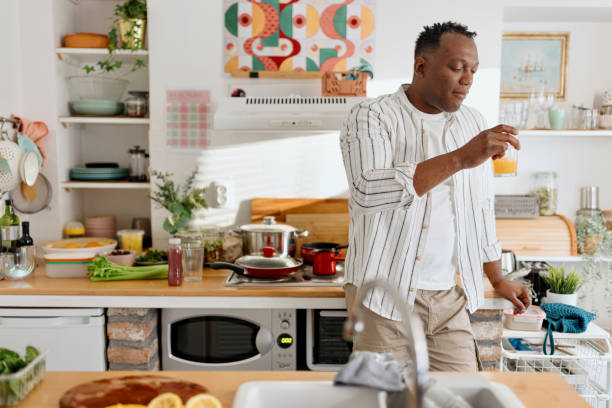 istock Black man drinking fresh orange juice 1477119489