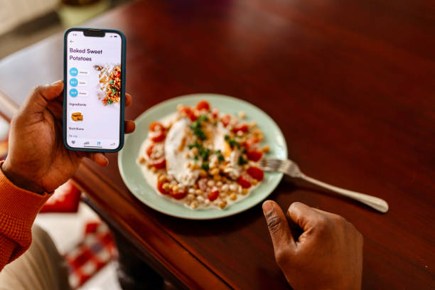 istock Man tracking calorie intake with a mobile app while enjoying a healthy meal 1477120661