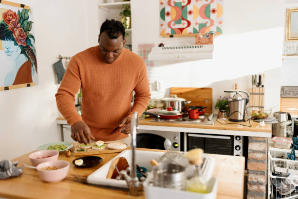 istock Man preparing healthy avocado and egg toasts 1477121200