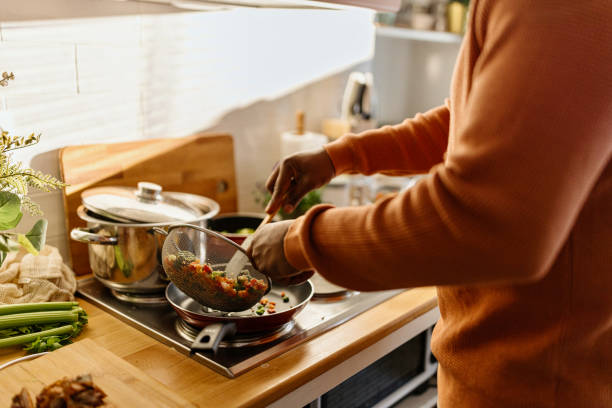Man preparing quinoa vegetable mix cooked in a frying pan