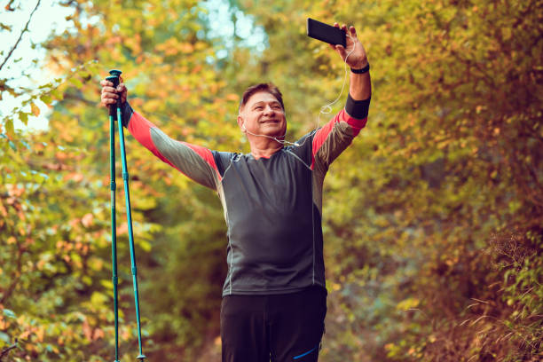 heureux randonneur senior prenant un selfie dans la nature - pointer stick audio photos et images de collection