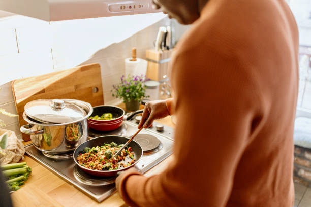 istock Man preparing quinoa vegetable mix cooked in a frying pan 1477121874