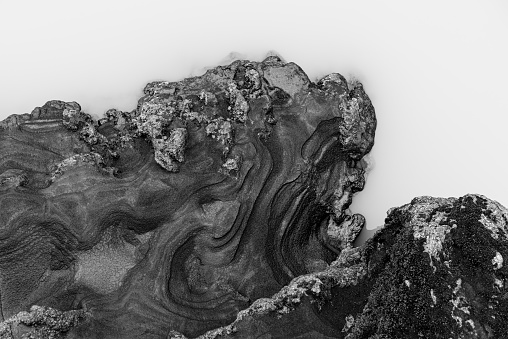 Abstract black and grey Iceland structure next to a muddy river in the Skaftáreldahraun lava field.