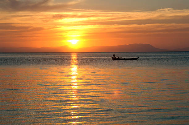 cambodian sunset with boat stock photo