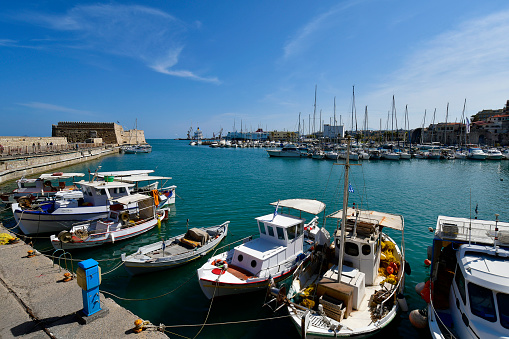 Iraklio, Greece - October 14, 2022: The capital of Crete Island, the small harbor for yachts and fishing boats with the Venetian Fortress Koules and old Venetian dockyards