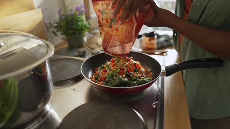 Woman preparing quinoa vegetable mix cooked in a frying pan