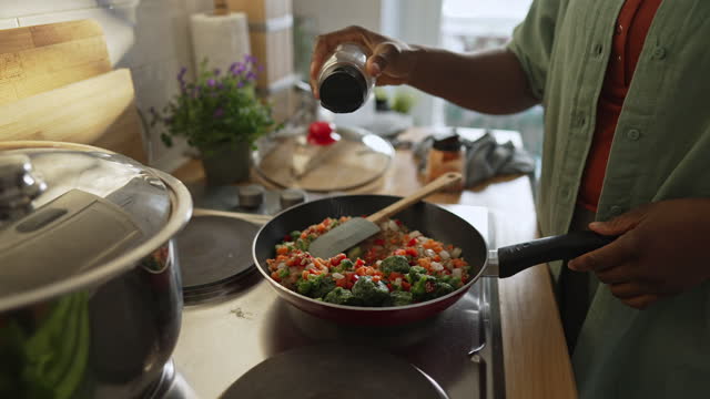 Woman preparing quinoa vegetable mix cooked in a frying pan