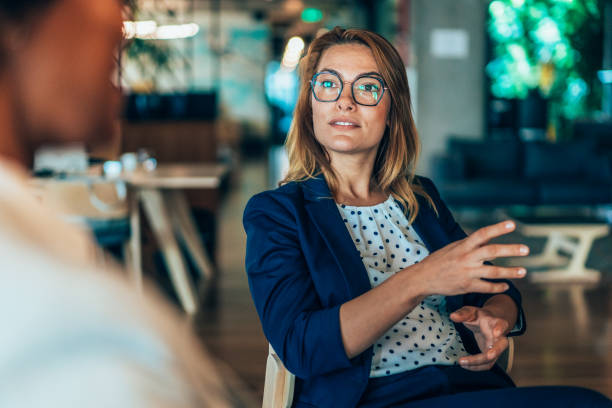 donna d'affari che parla con un collega - gesturing two people business talking foto e immagini stock