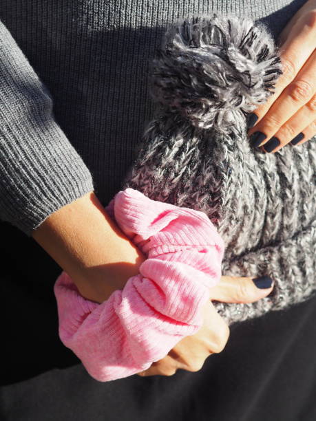 istock Pink scrunchie on a woman hand and wool gray cap 1477137222