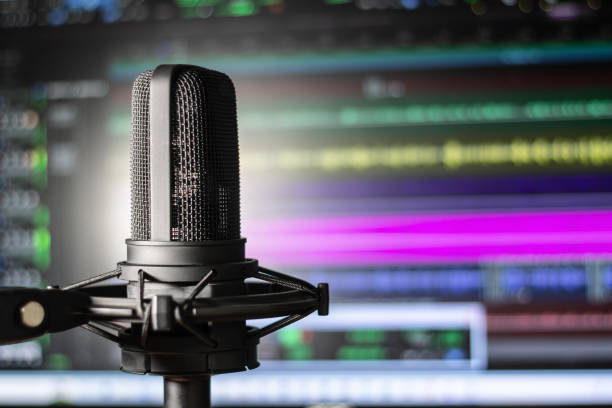 istock Recording studio vocal microphone with audio editing background. Colorful home studio session with mic and computer. 1477137606
