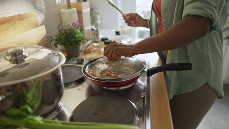 Woman preparing quinoa vegetable mix cooked in a frying pan