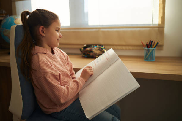 istock Schoolgirl studying at home 1477140395
