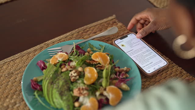 Woman checking nutrition information and calories on her phone when eating