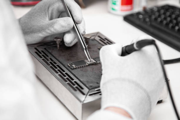 istock The master solders the microchip. Repair of microelectronics. Service center. 1477143390