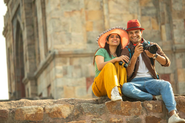 istock Couple admiring view using binoculars and camera at historic site 1477144366