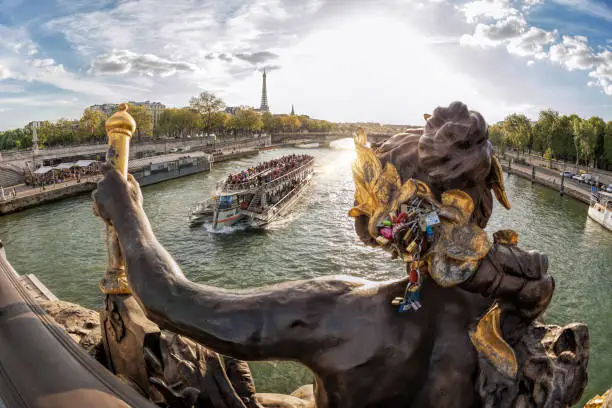 Photo of The Pont Alexandre III (bridge) with sculptures against tourist boat on Seine and Eiffel Tower in Paris, France