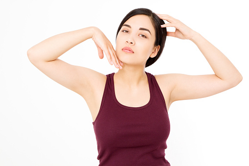 Skin care and armpit concept. Make up and cosmetics. Young asian woman isolated on white background in summer shirt. Copy space.