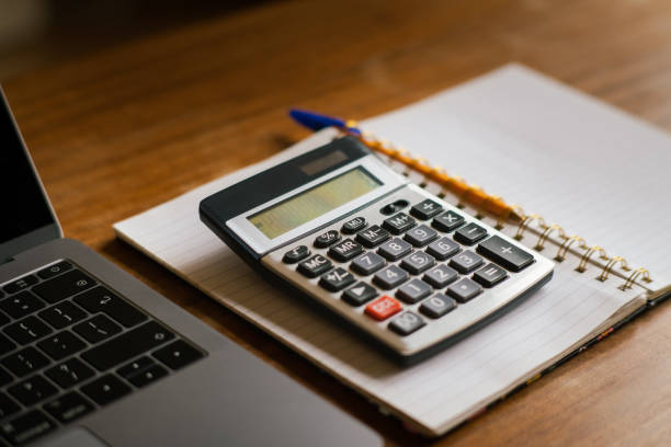 istock counting bills, accountant table with glasses, calculator and notes 1477146694