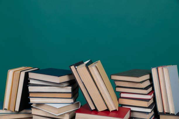 istock many books stacked on a table on a green background in the science knowledge library 1477146864