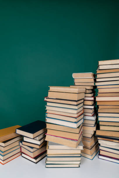 istock many books stacked on a table on a green background in the science knowledge library 1477146928