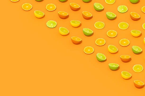 istock Lime and Orange Fruit Slices with Sunlight on Orange Color Background 1477147016