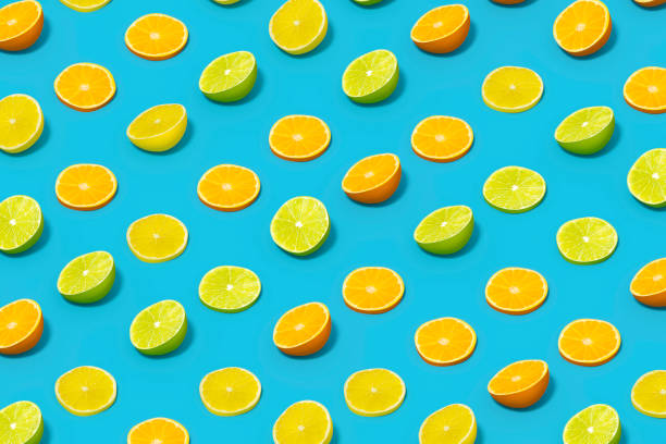 istock Lime and Orange Fruit Slices with Sunlight on Blue Color Background 1477147094