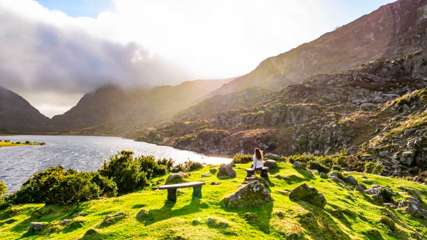 The Gap of Dunloe (from Irish: Dún Lóich, meaning 'Lóich's stronghold'), also recorded as Bearna an Choimín (meaning gap of dunloe, county kerry, irlanda, mujer observando el lago desde el punto de vista, siendo libre en la naturaleza, mujer fuerte en la naturaleza, mujer escalando montaña, fotografía cinematográfica de la naturaleza, relajación meditación naturalez