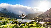 Aerial view of Gap of Dunloe, County Kerry, Ireland, woman watching lake from view point, being free in nature, strong woman in nature, woman saluting nature, cinematic nature photo, relaxation meditation nature, woman relaxing in nature