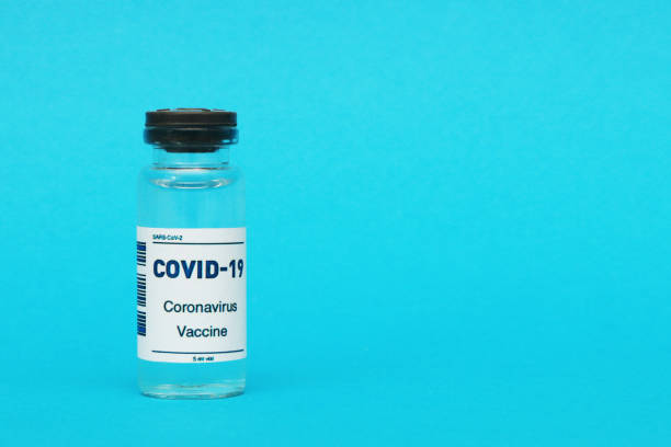 istock Covid-19 vaccine ampoule on a blue background. 1477153003