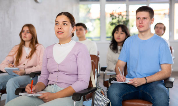 istock Interested girl student listening and taking notes of lecture 1477155023