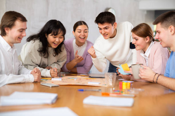 istock Group of positive younger people playing tabletop game 1477155100