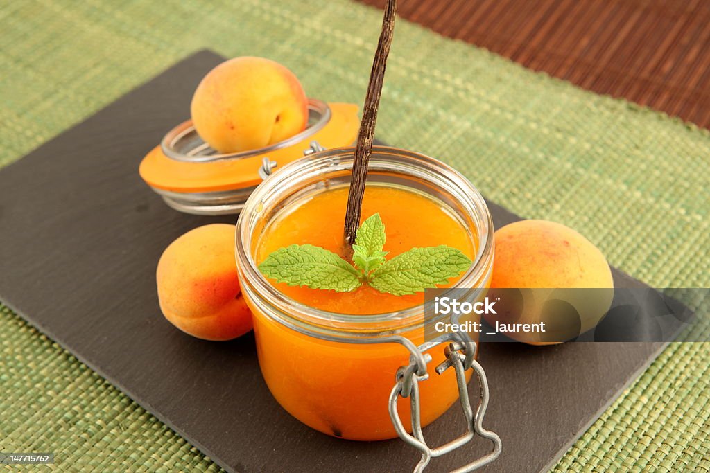 Apricot jam Close up of glass jar with homemade apricot jam, mint leaf and vanilla Apricot Stock Photo