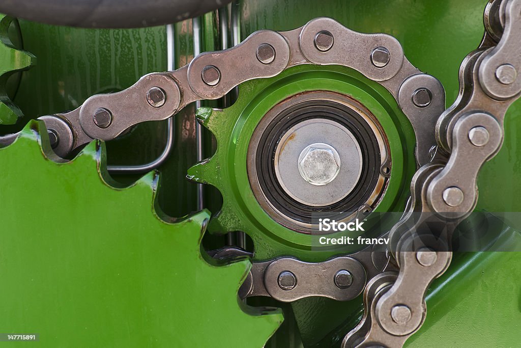 Strong chain on the machine in green Strong chain of the agriculture chain ring is shining in the afternoon sun. Chain - Object Stock Photo