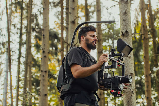 Videographer with Professional Movie Video Camera Gimbal Stabilizing Equipment Taking Action Shoot of Soldiers in Action in Forest