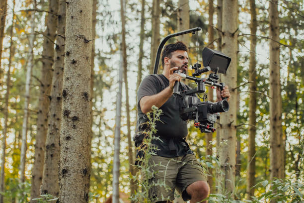 istock Videographer with Professional Movie Video Camera Gimbal Stabilizing Equipment Taking Action Shoot of Soldiers in Action in Forest 1477162114