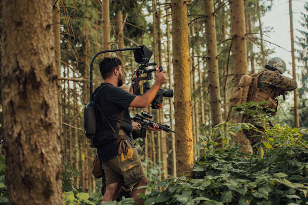 istock Videographer with Professional Movie Video Camera Gimbal Stabilizing Equipment Taking Action Shoot of Soldiers in Action in Forest 1477162727