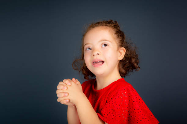 Beautiful and happy girl making gestures with both hands. Isolated on gray background.