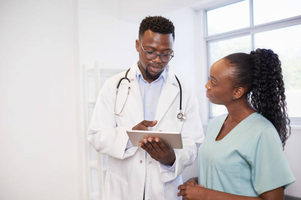 istock Two Black healthcare professionals discuss patient case on digital tablet 1477177187