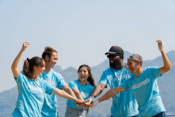istock volunteers joining hands stack together and raising hands with smile 1477180772