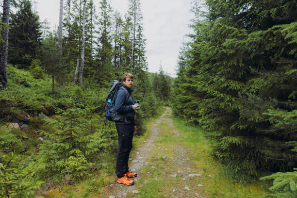istock Side view of man with backpack hiking in the forest in Norway 1477181006