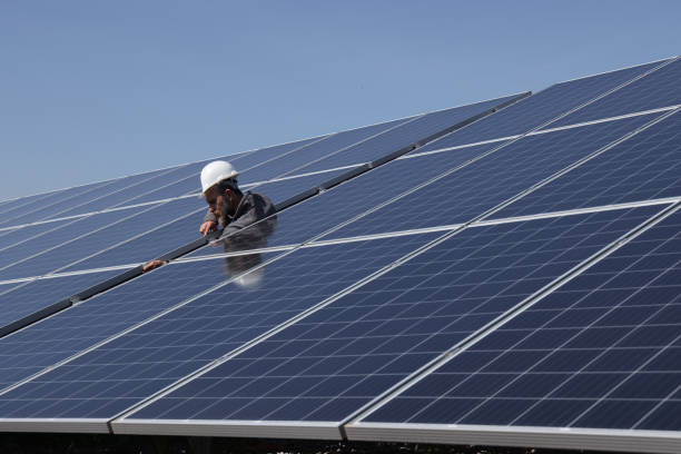 istock Male engineer installs alternative energy solar panels. 1477181314