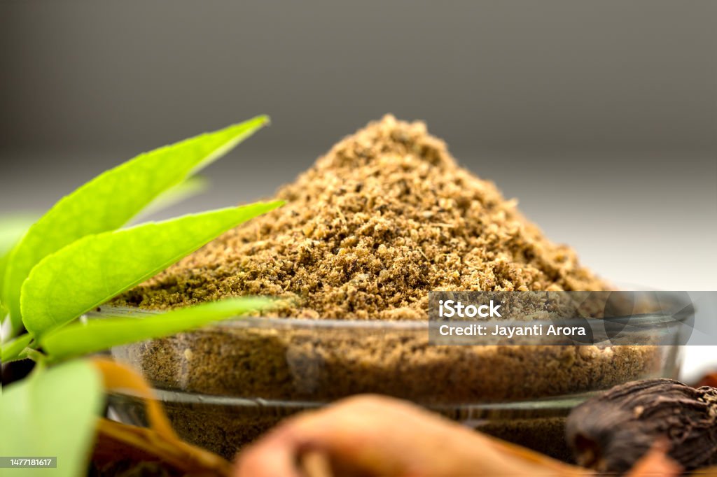 Garam masala in bowl with green curry leaves Agriculture Stock Photo