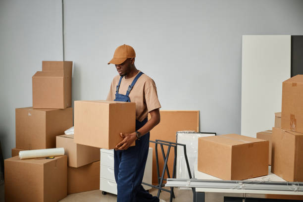 Worker carrying cardboard boxes in office stock photo