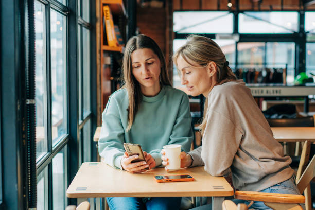 istock Two modern women make purchases on websites using a mobile phone. 1477182637