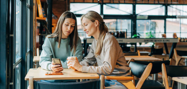 istock Two modern women make purchases on websites using a mobile phone. 1477182875