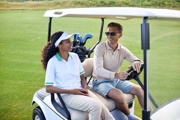 istock Multiethnic couple driving golf cart and smiling cheerfully 1477183427